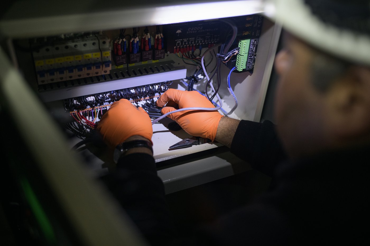 Técnico Australtec cableando el tablero de control de un grupo electrógeno